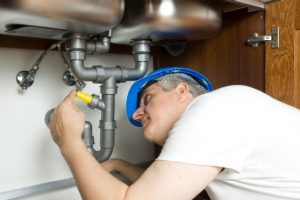 picture of a plumber checking sink drain