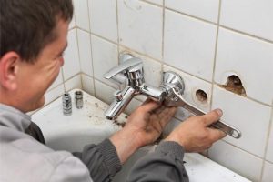 plumber removing old faucet photo