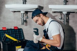 plumber with a wrench photo while installing bathroom sink