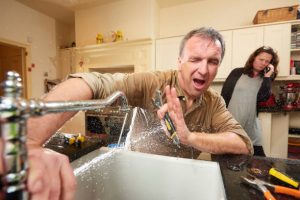 plumber fixing the broken faucet photo